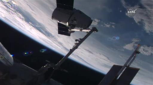 國際太空站上的太空人用機械臂抓住飛龍號太空船